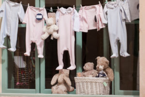 kleine baby strampler auf der wäscheleine im schaufenster